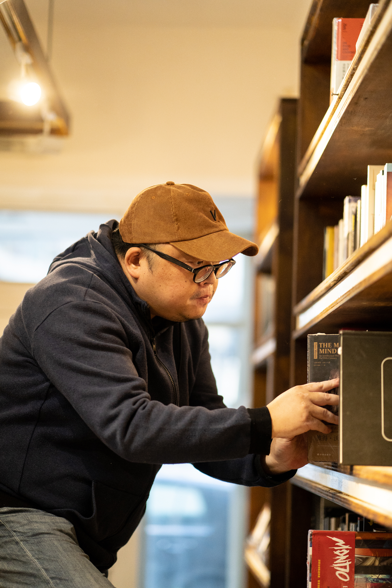 Anson Ng, owner of Pin-to Livros & Musica, shelving books