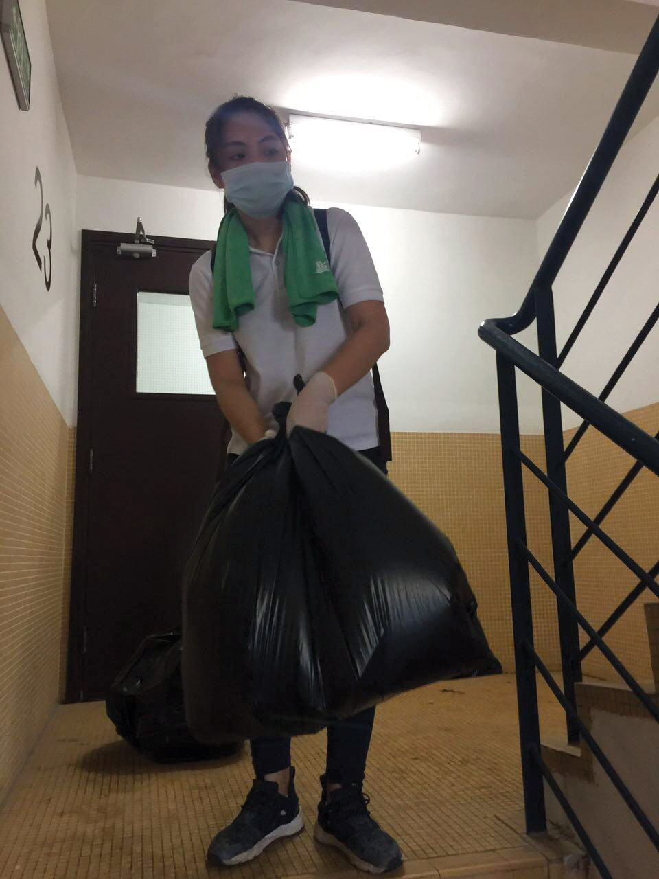 Emma Chan takes a trash bag down flights of stairs to help the elderly | Photo Courtesy of Emma Chan