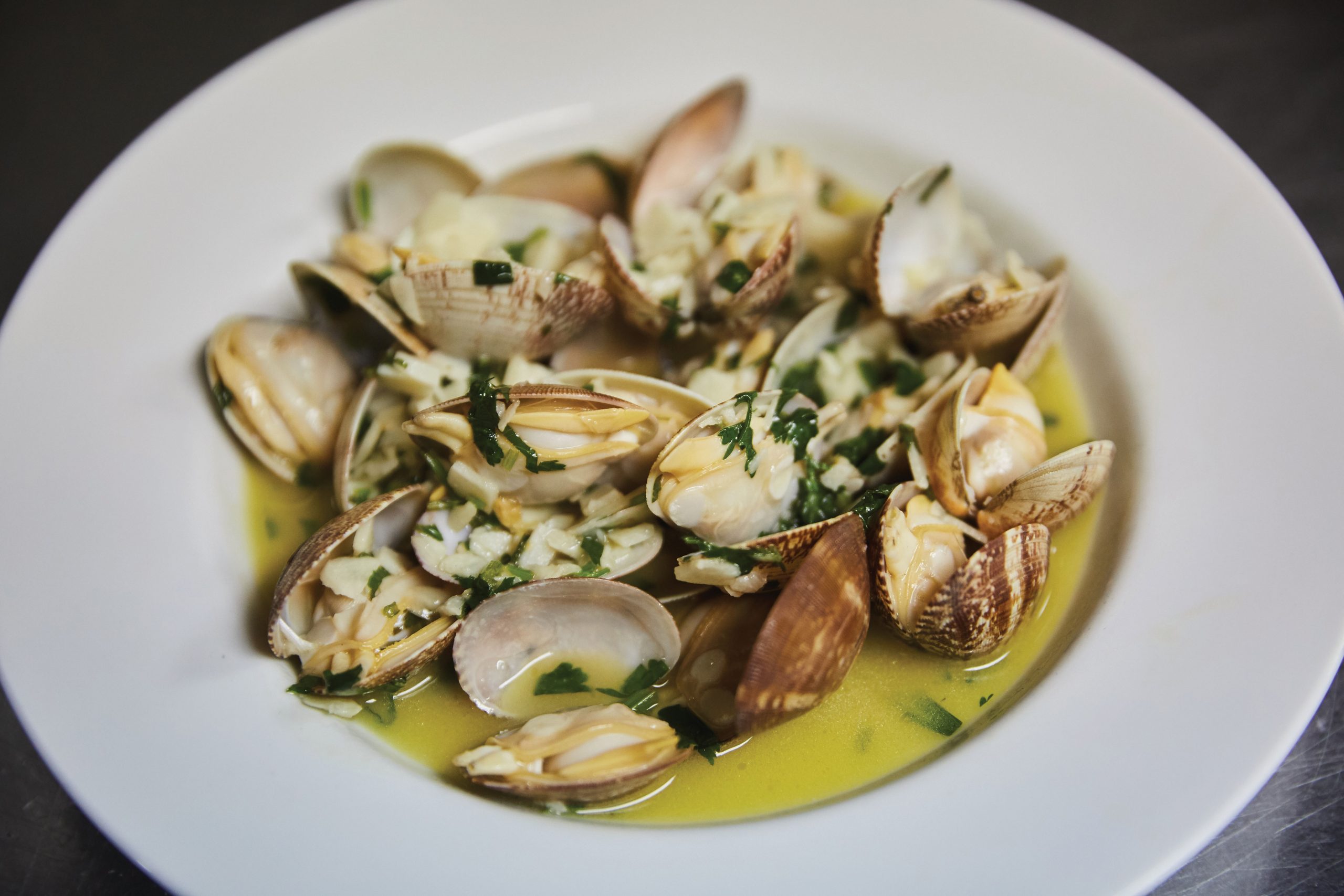 The club’s version of clams with lemon and garlic in ‘bulhão pato’ sauce, which uses fresh coriander as a main ingredient - Photo by António Sanmarful