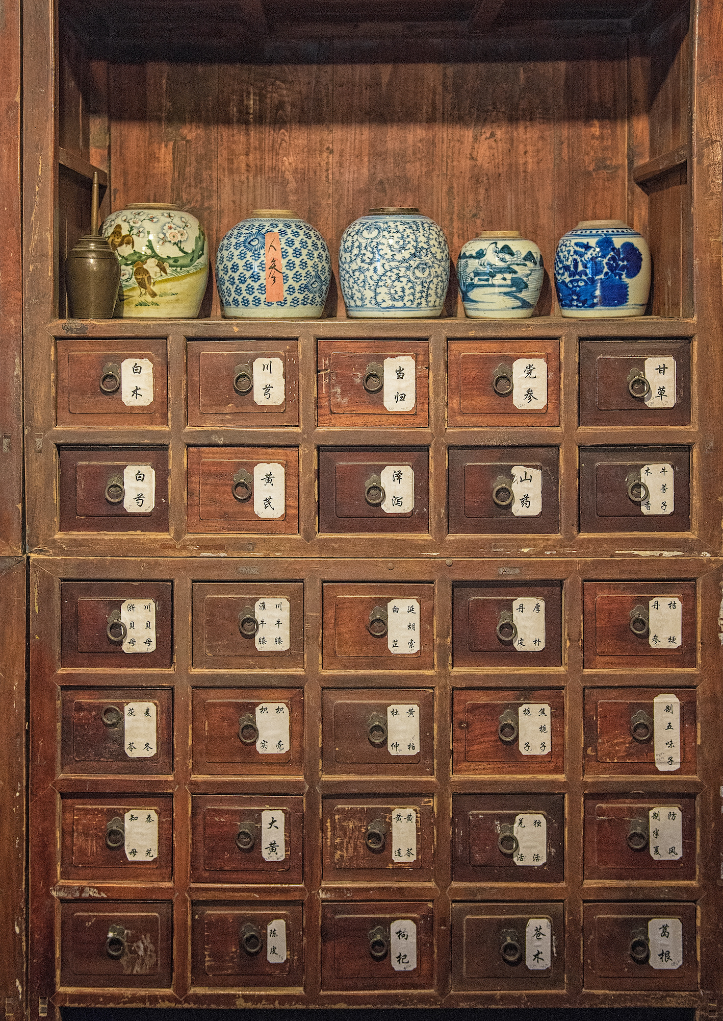 Traditional Chinese Medicine remedies inside a pharmacist's old cabinet