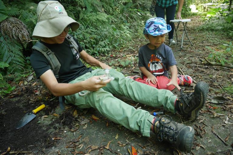 Leong leading a group of parents and children to explore green areas in Macao