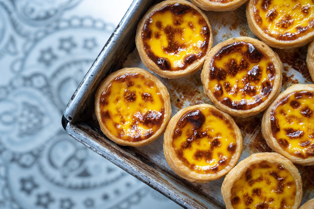 How do Macao’s egg tarts differ from Portuguese pastéis de nata?