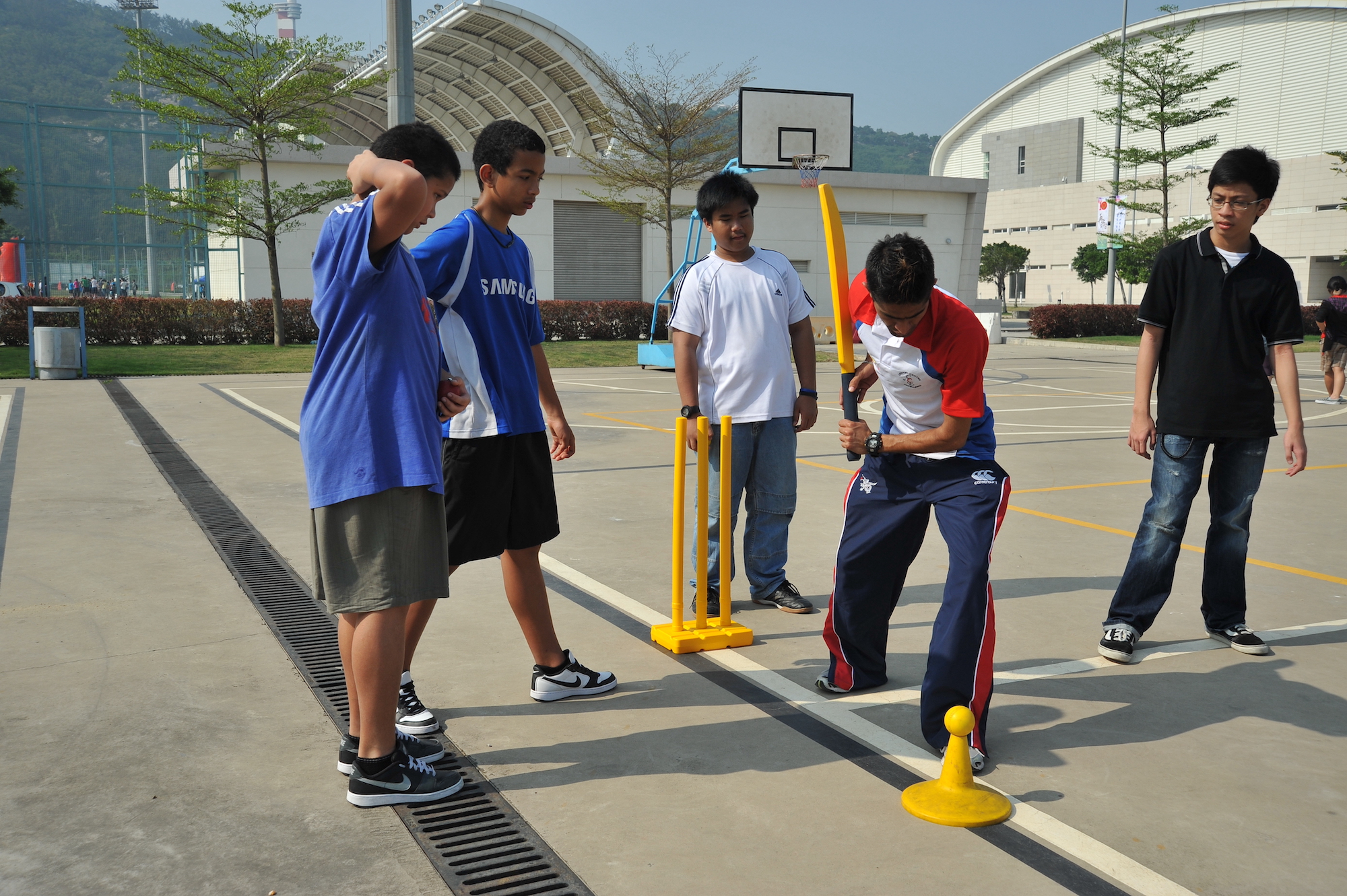 A member of Hong Kong’s Omnicon cricket team demonstrates a straight drive during a coaching camp in 2010 at the International School of Macao