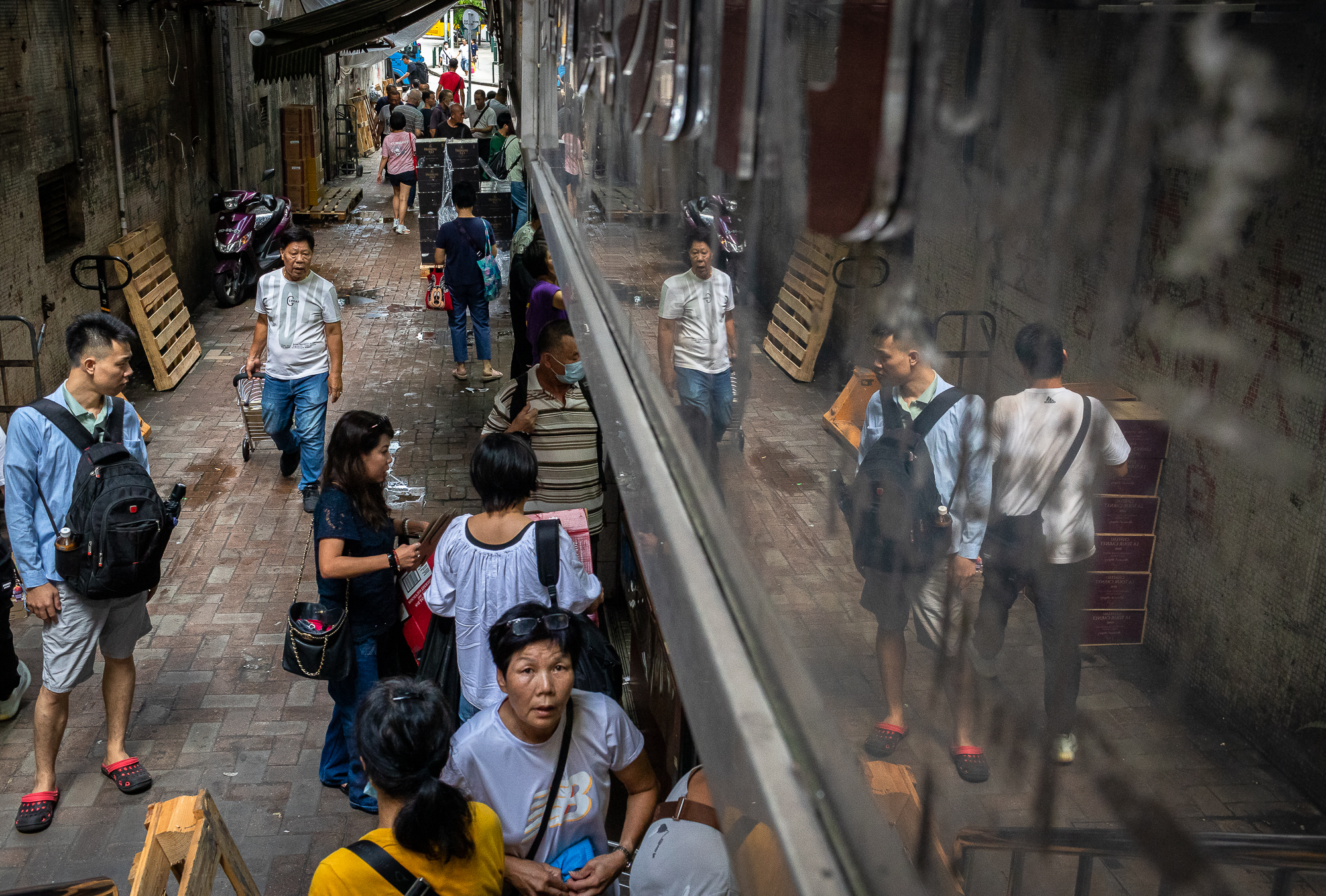 Shoppers buy drinks in an alley next to the Border Gate