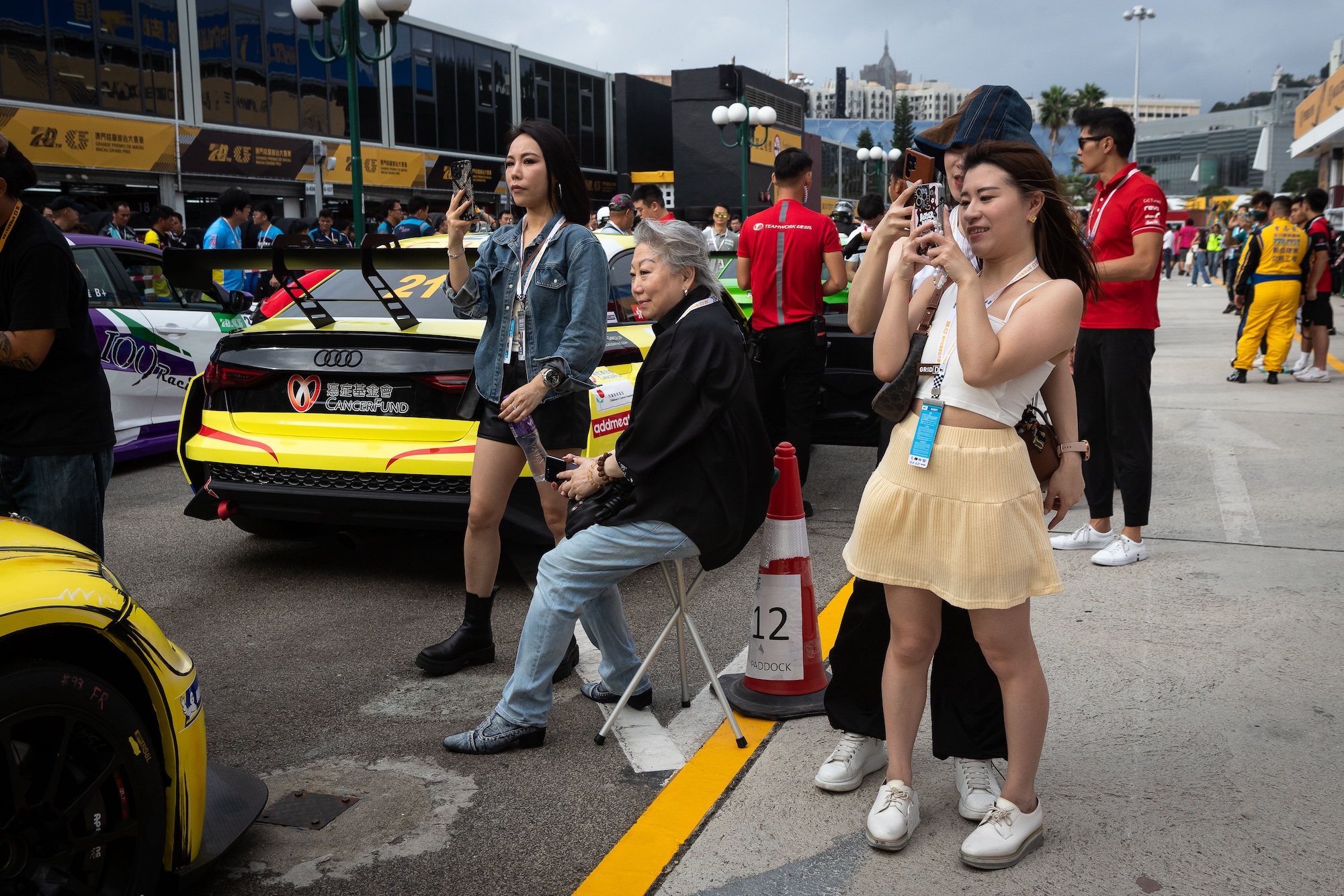 Excited members of the public take photos of race cars at the paddock at the 2023 Macau Grand Prix