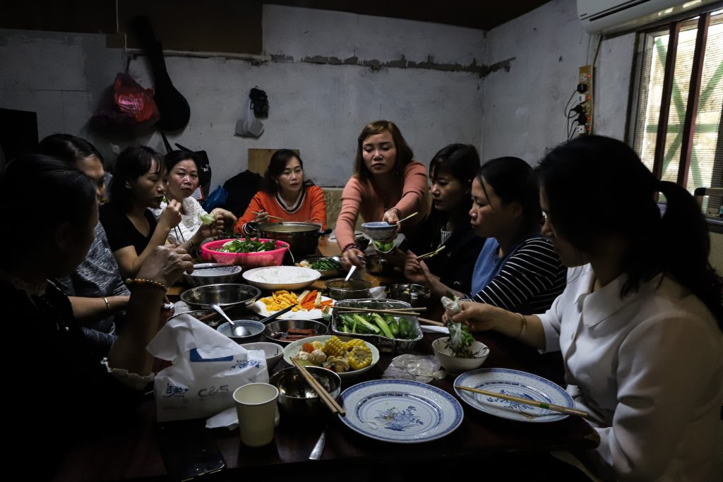 Nguyen Hai, 48, helps herself to food during Sunday lunch at the house that she shares with eight other Vietnamese women in Macao, on 19 November, 2023. Most Vietnamese in Macao are female domestic workers