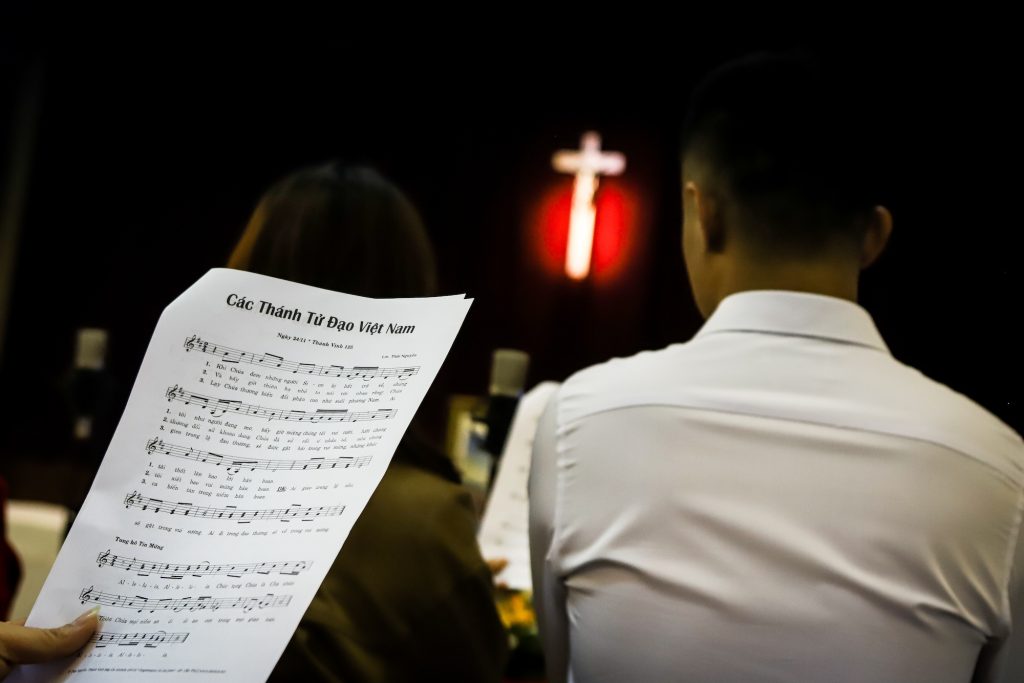 A member of the congregation follows a hymn at Vietnamese-language Macao's Mass at Our Lady of Fátima
