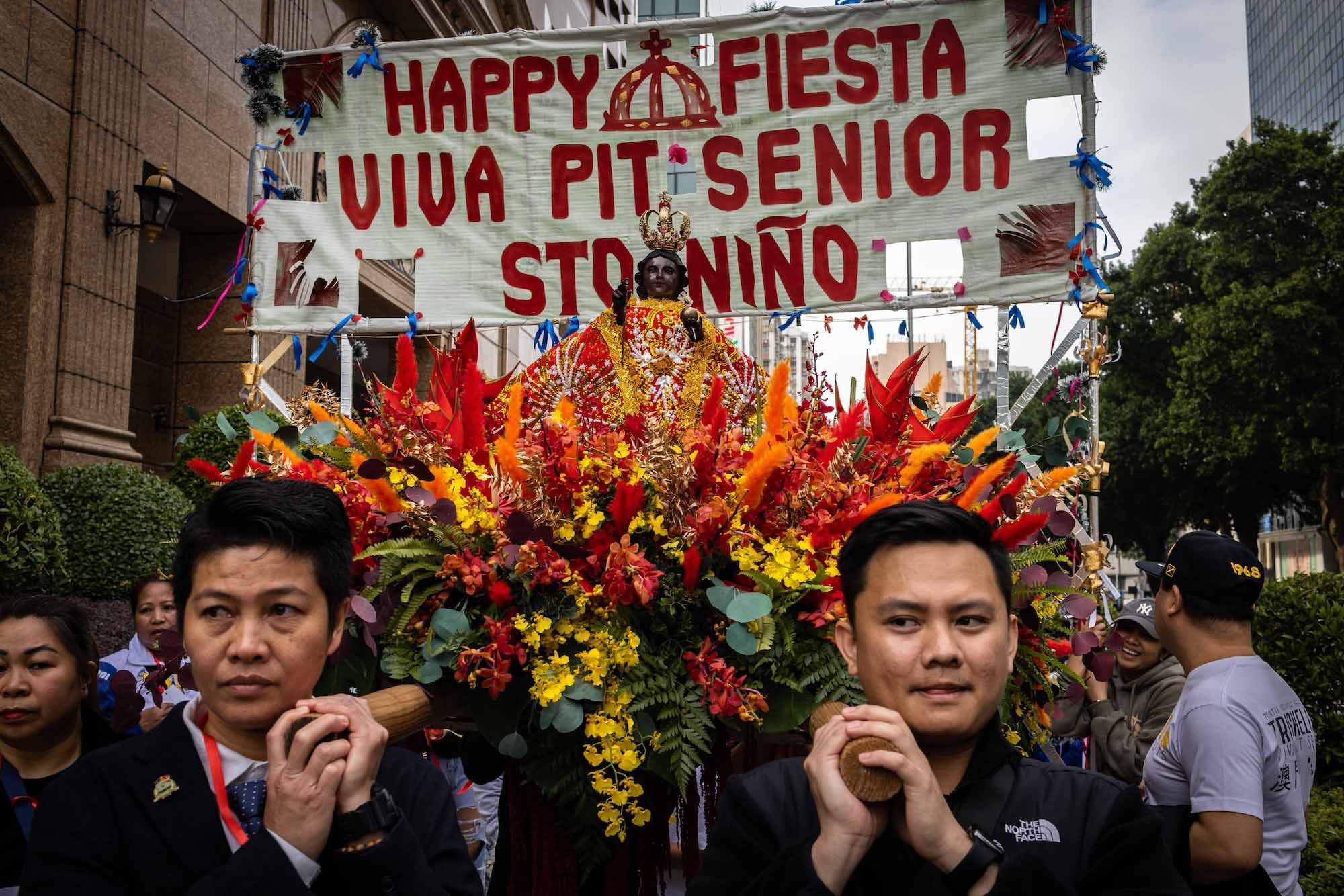 Two members of the Sinulog Festival’s organising committee help carry a litter with a figure of the Infant Jesus through the streets of Macao