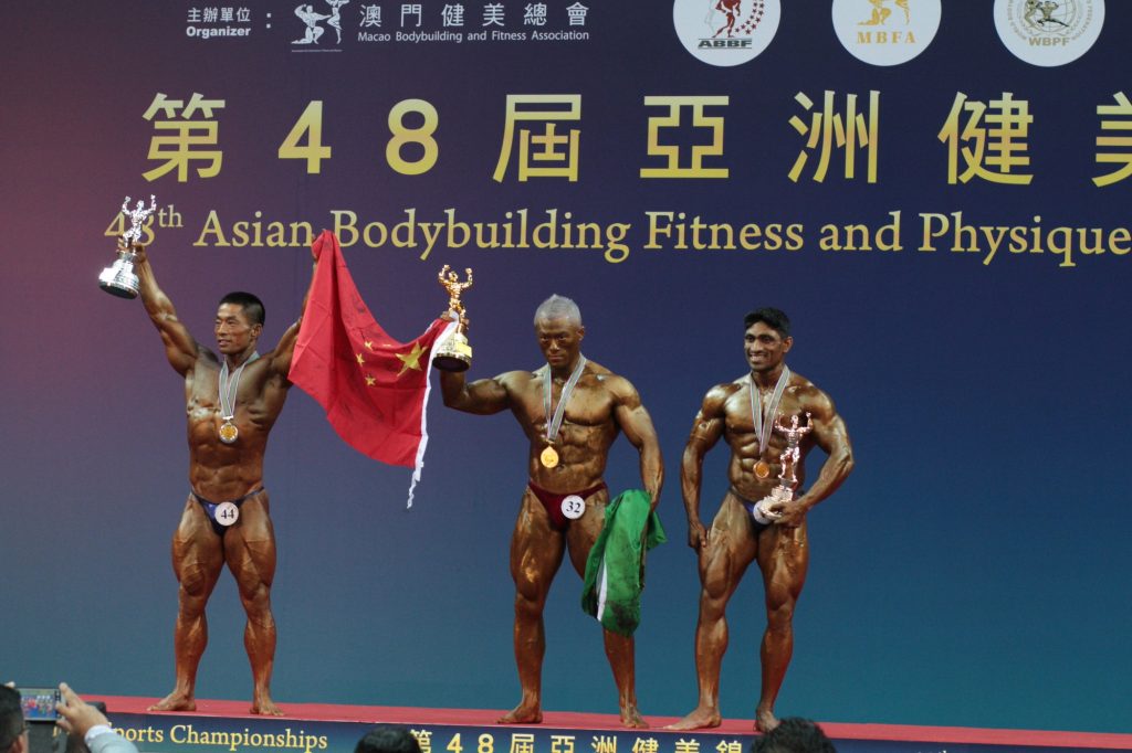 Iao (centre) winning the grand prize at the 48th Asian Bodybuilding Fitness and Physique Sports Championship in 2014