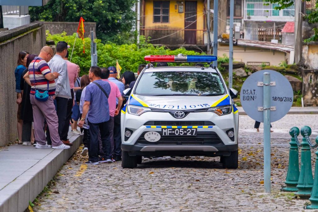 A police vehicle is seen parked beside a group of tourists at the Ruins of St. Paul’s in this photo from April 2019