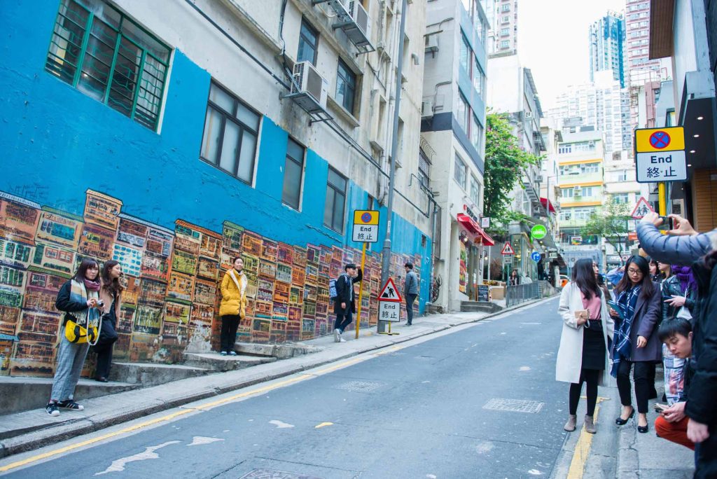 Visitors pose for photos at Alex Crofts mural of shophouses in Hong Kong’s SoHo district on 12 January 2018