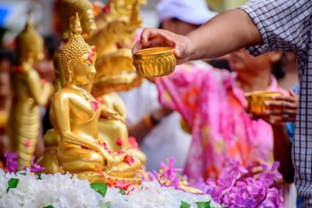 A celebrant ritually pours water over a Buddha statue at an undisclosed location on Thailand on 13 April 2017