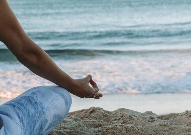 A man has been told to stop giving free yoga classes on a Californian beach