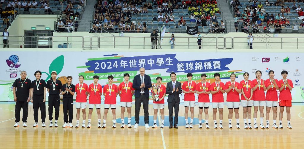 Members of the winning Chinese school basketball team pose with officials at the conclusion of the tournament