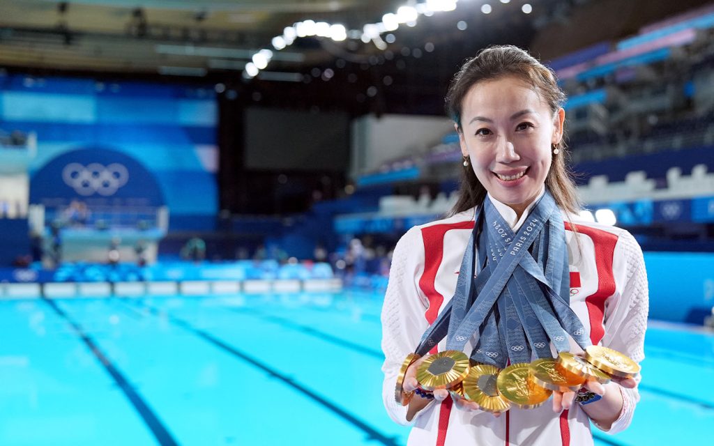 Head coach Zhang Xiaohuan of the Chinese artistic swimming team shows medals clinched by Chinese swimmers after the victory ceremony at the Paris 2024 Olympic Games on 10 August 2024