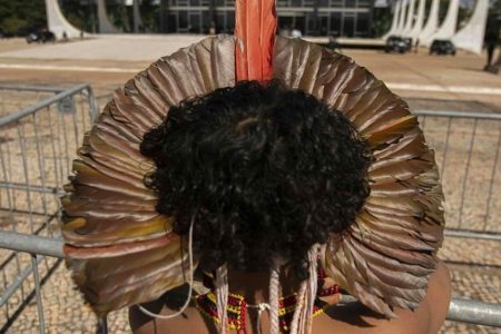 An Indigenous protester against the controversial constitutional amendment stands outside the National Congress of Brazil in Brasilia