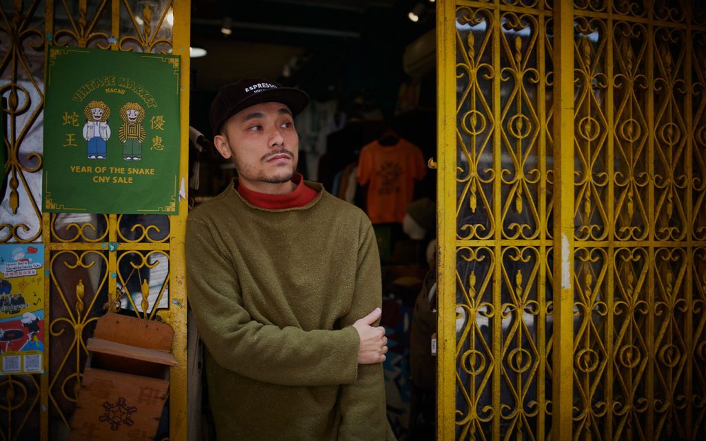 Terrance, the proprietor of a vintage clothing boutique in St. Lazarus, waits for customers at the entrance of his store