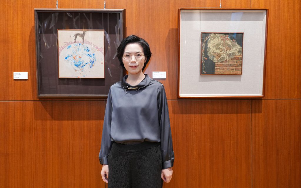 Artist Leong Kit Man poses alongside some of her work on display at the Mandarin Oriental