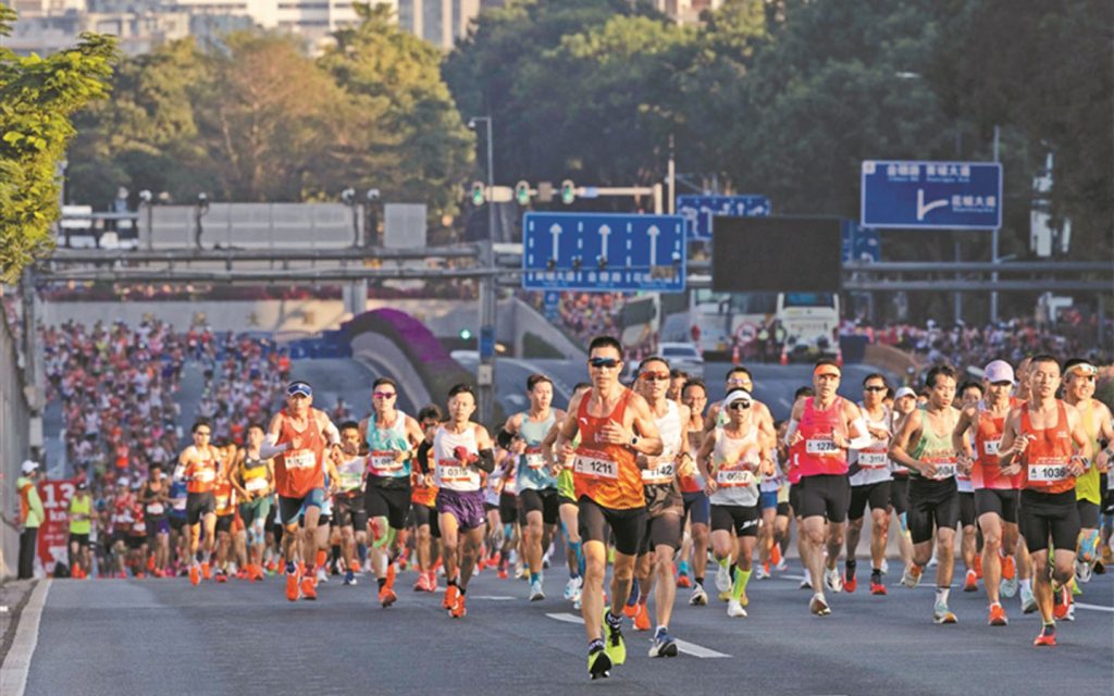 Runners race along the Pearl River, passing landmarks such as Canton Tower at the Guangzhou Marathon