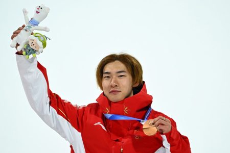 Bronze medalist Su Yiming gestures during the awarding ceremony at the Milan-Cortina 2026 Olympic Winter Games